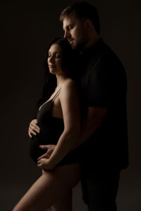 Mom & dad posing for studio maternity portrait session after visiting best ob/gyn in Gilbert, Arizona