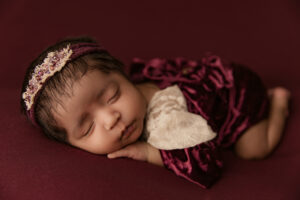Baby posed in velvet outfit for newborn portraits in phoenix