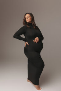 Mom posing in black dress for studio maternity portraits in Phoenix 