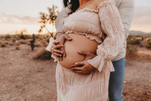 Pregnant mother posing at lost dutchman for maternity portrait session with husband