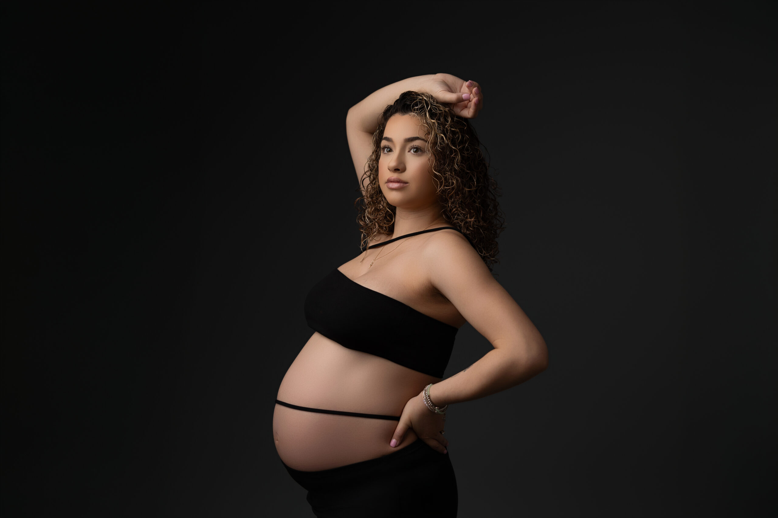 hispanic mother posing for maternity portrait session in phoenix maternity photo studio