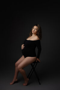 Pregnancy picture in maternity portrait studio mom in black body suit for luxury maternity photoshoot