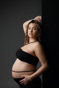 Mom wearing two piece black outfit for maternity session with a luxury maternity photographer