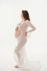 Maternity portrait session in Phoenix on White backdrop with White maternity gown 