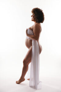 Pregnant mother posing with silk sheet for maternity portrait session in Phoenix editorial maternity shoot