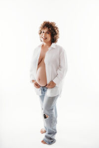 Mom posing in jeans and white shirt for pregnancy photos at Phoenix photography