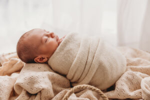 Baby in a Moses basket posing for newborn session in scottsdale newborn photography studio