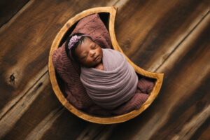 Baby girl in a newborn prop for newborn photography session