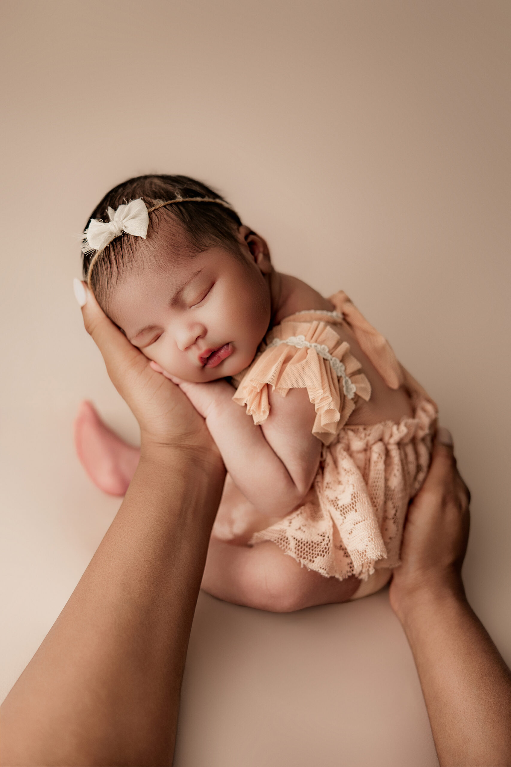 black newborn baby posing in newborn session cradled in moms hands for baby photos in phoenix Arizona