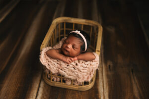 Baby posing in bucket for baby portraits in phoenix