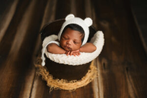 Baby girl in bear bonnet in a bucket for baby pictures in phoenix