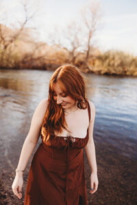 Girl in red dress posing at salt river in Phoenix Arizona for senior session 