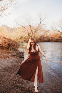 Girl in red dress posing  at salt river in Phoenix Arizona for senior session 