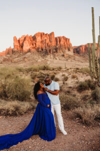 Sunset maternity session at lost dutchman state park with black mom  in blue dress and husband 