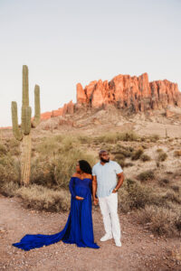 Sunset maternity session at lost dutchman state park with black mom  in blue dress and husband for destination maternity session