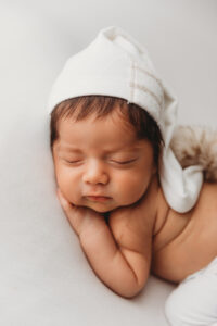 best newborn photographer in Phoenix baby boy in neutral outfit for newborn photography session
