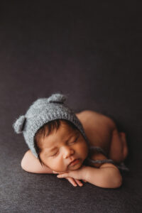 Baby boy posing in bucket for newborn session in Phoenix Arizona at the best newborn photography studio