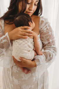 Mom holding newborn baby during lifestyle newborn session in phoenix