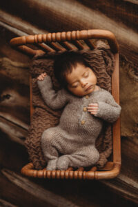 Baby boy posing in bucket for newborn session in Phoenix Arizona at the best newborn photography studio