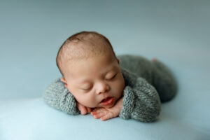 Baby boy in blue during newborn session in Phoenix