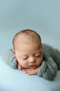 Baby boy in blue during newborn session in Phoenix