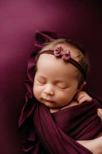 baby girl in orchid color for newborn session in phoenix