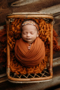 Baby girl wrapped in orange for newborn pictures