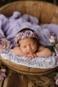 baby girl in purple floral headband for newborn pictures 