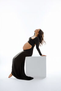 Mom in black dress showing pregnancy belly for scottsdale maternity photography studio