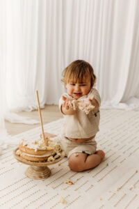 baby with cake in hands at phoenix studio for photography
