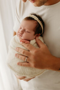 dad holding newborn baby in scottsdale newborn photography studio