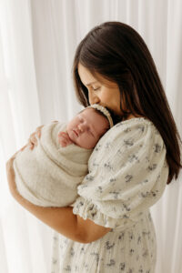 mom holding newborn baby in scottsdale newborn photography studio