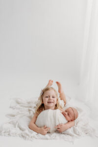 big sister holding baby during a newborn photoshoot in phoenix 