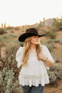 high school senior girl wearing jeans in phoenix desert for senior pictures