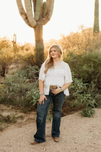 high school senior girl wearing jeans in phoenix desert for senior pictures